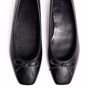 Svarta ballerinaskor med rosett från NA-KD - Snygga svarta (slutsålda) ballerinaskor från NA-KD med fyrkantig tå och en liten rosett framtill. Endast använda 1 gång🤍Köpta för 500