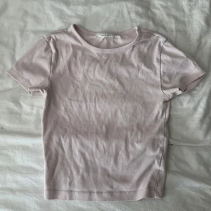 Ljusrosa basic t-shirt från Basic Basics - En enkel och stilren ljusrosa t-shirt från Gina tricot. Modellen är tajt passform med rund halsringning och korta ärmar. Tillverkad i mjuk bomull som känns skön mot huden. Perfekt att matcha med jeans eller kjol för en clean look. Något urtvättad men i fint skick 💗