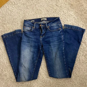 Blå jeans från LTB - Snygga blå jeans från LTB med bootcut-ben och klassisk femficksdesign. Jeansen har en mörkblå tvätt med ljusare slitningar framtill och bakfickor med dekorativa sömmar. Storlek W24 L30