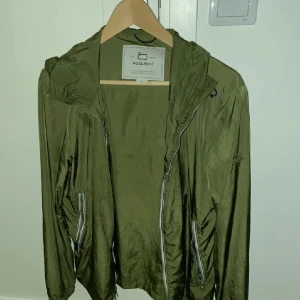Woolrich Windbreaker - Säljer en grön Woolrich Windbreaker som passar perfekt nu till hösten. Använd sparsamt och har inga tecken på slitage. Nypris: 3600