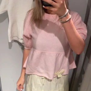 Ljusrosa stickad kortärmad tröja  - Supersöt ljusrosa stickad tröja med volang nertill och korta ärmar