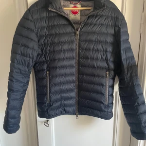 Mörkblå pufferjacka från Colmar - Snygg mörkblå pufferjacka från Colmar Originals. Säljer då den inte kommer till användning. Ny pris runt 1500-2000kr. Inga synliga defekter. Kontakta vid funderingar.
