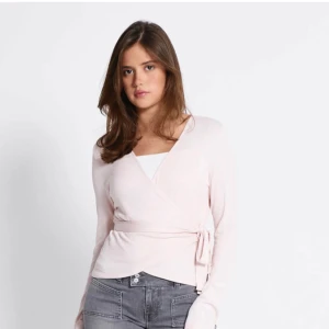 Ljusrosa omlottopp med knyt - Supersöt ljusrosa omlottopp med knyt i sidan och v-ringad hals. 