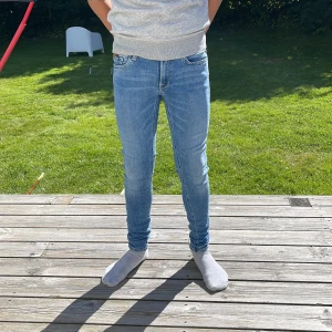 Replay skinny jeans i ljusblå denim - Säljer ett par snygga Replay skinny jeans i ljusblå denim med klassisk sexficksdesign och dragkedjedetalj vid ena fickan. Jeansen har låg midja och smal passform som sitter tight hela vägen ner. Perfekta för dig som gillar en modern och stilren look. Pris kan diskuteras  