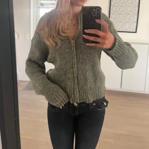 Grön stickad kofta - Säljer denna sköna kofta som jag tyvärr inte vet vart den är ifrån, men i superfint skick. 