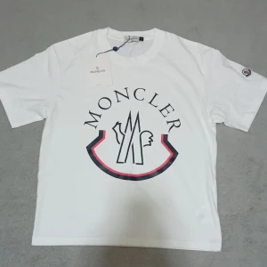  Moncler t-shirt  - Säljer en vit t-shirt från Moncler den är helt ny o den är oanvänd. Man kan se taggen o att den e ny. Priset kan diskuteras genom snabb äffer.