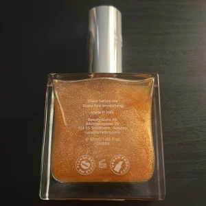 CAIA The Glow Oil shimmerolja - Säljer CAIA The Glow Oil, en lyxig kroppsolja med guldskimrande finish. Innehåller avokadoolja och vitamin E för extra glow. Kommer i en snygg fyrkantig glasflaska med silvrig kork. Perfekt för att ge huden en glittrande, solkysst look.