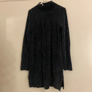Mörkgrå stickad klänning från C - Säljer en mysig mörkgrön stickad klänning från C i storlek XS. Klänningen har lång ärm, ribbad struktur och hög krage. Perfekt för dig som gillar oversized känsla och vill ha något varmt och stilrent under höst och vinter.
