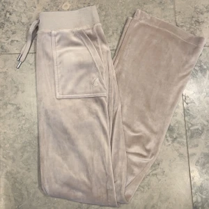Juicy Couture byxor - Ny skick, knappt använda. Storlek Xs, färgen string. Lappen har jag klippt bort då jag ville kunna vika ner dom.  Har även ett par andra juicy byxor till salu i storlek xxs i färgen rosa💗 