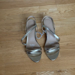 Guldiga klackar - Säljer mina guldiga klackskor med låg klack. Från H&M, storlek 38 och aldrig använda 💕💕💕