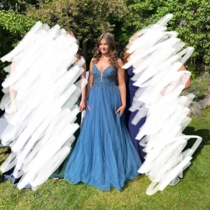 Blå balklänning  - Säljer min underbara blå balklänning som jag bar på balen 2025! Klänningen har glittrig överdel och djup v-ringning, snörning i ryggen. Köpt på dream designs i Motala i mars och använd endast vid baltillfället. Nypris: 5000 kr. Säljes för: 3000 kr. Stl: passar någon som vanligtvis brukar ha stl 36. Uppsydd efter mig, jag är 170 cm lång och bar 6 cm klack på balen. Kan tänka mig gå ner o pris vid snabb affär! Skriv gärna till mig vid fler frågor :) 