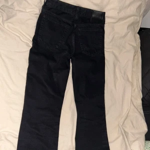 Svarta jeans med rak passform - Snygga svarta jeans med rak passform och klassisk design. De har en dragkedja och knapp framtill samt fem fickor. Perfekta för en stilren look.