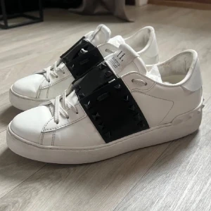 Valentino Skor - Snygga vita sneakers från Valentino med svarta detaljer och nitar. Skorna är köpta för ca 6000kr, en nit på vänstra skon saknas, använda men bra skick. Medföljer ej kartong eller dustbag. Kan sänka priset vid smidigt köp