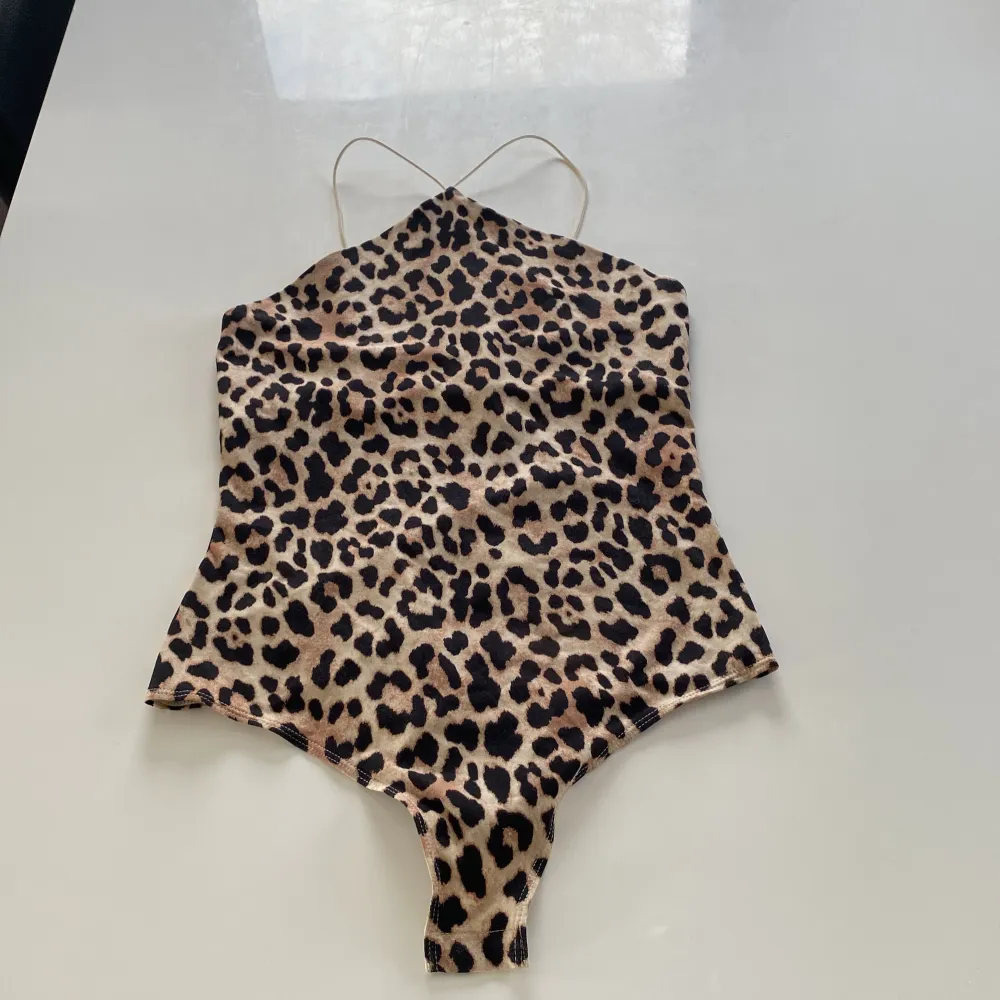 Snygg leopardmönstrad bodysuit med smala band runt nacken. perfekt för sommaren . Yläosat.