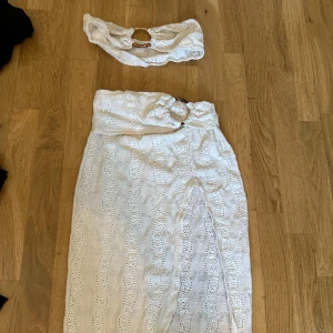 Top & kjol sett - Snygg vit långkjol med och en slits framtill. Kjolen har ett vackert mönster och en top.