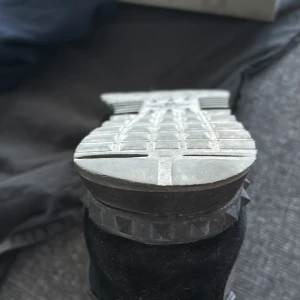 Valentino Rockrunners - Snygga sneakers med ett coolt camouflage-mönster och nitar runt sulan. Skorna har snörning och en rund tå, vilket ger en bekväm passform. Perfekta för en trendig look.