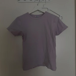 Ljuslila t-shirt från Filippa K - Säljer en stilren ljuslila t-shirt från Filippa K i storlek L. T-shirten är tillverkad i mjuk bomull och har en klassisk rund halsringning. Perfekt för en avslappnad look.