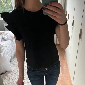 Svart topp med volangärmar från Zara - Snygg svart topp med volangdetaljer på ärmarna. Nyskick, aldrig använt. 