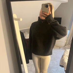 Grå stickad polotröja - Säljer en mysig grå stickad polotröja med hög krage. Tröjan har långa ärmar och en avslappnad passform, perfekt för kyliga dagar. Den är både stilren och bekväm, ett måste i garderoben!