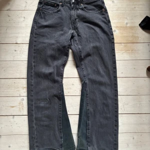 Svarta bootcut jeans - Snygga svarta jeansbyxor med en klassisk femficksdesign. De har en flared/bootcut form och är perfekta för en avslappnad stil. Byxorna har en knapp och dragkedja framtill.