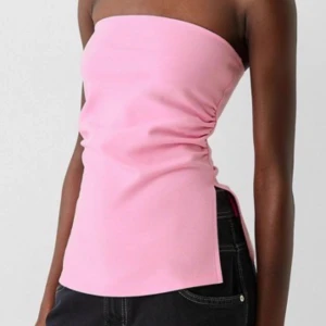 Rosa tubtopp - Säljer en söt rosa tubtopp i mjukt material. Perfekt för sommardagar och kan enkelt matchas med olika outfits. Toppen har en enkel design utan axelband. Men en snygg slits ner till. Aldrig använd. 