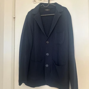 Mörkblå cardigan med mönstrad krage - Snygg mörkblå kavaj från Pizhon med en unik mönstrad krage som man kan vika ner. Storlek M. Super snyggt att ha till vardagen eller om man va lite finklädd. Bekväm och bra kvalitet. Skriv ifall du har frågor!🤍