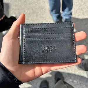 Säljer en svart plånbok från boss. Den ör helt ny aldrig använd och alla som har sett den haf tyckt den va skit snygg. Kan hålla många kort och cash. Pris kan diskuteras, om du köper Kepsen och plånboken samtidigt får du båda för 500