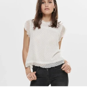 Vit blus med spetsdetaljer - Säljer en söt vit blus med korta ärmar och spetsdetaljer. Blusen har ett diskret prickigt mönster och en liten öppning i ryggen. Superfin🥰