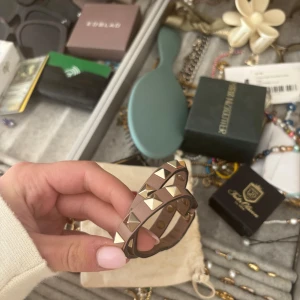 Brunt armband med nitar från Valentino - Snyggt armband från Valentino med guldiga nitar. Har blivit lagat i slutningen, inget som märks eller syns när man har det på sig. Nypris runt 3500kr säljer för 1500kr 💙