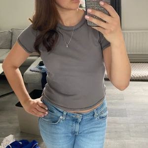 Grå ribbad t-shirt - Säljer en stilren grå ribbad t-shirt med korta ärmar. 