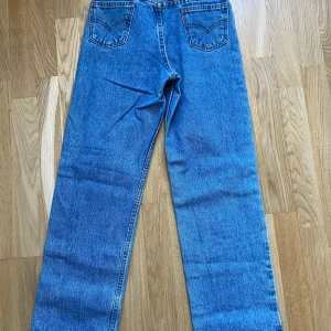 Levis  - W27 L27 Midja 68cm¦ Benlängd 68cm¦Bredd över lår 27cm  Made in the U.S Levi's 562, 90-tal. Byxan är högmidjad och loose fit. Mer utrymme för lår och ben. Byxorna är gjorda i USA och tillhör Levi's orange tab kollektion.