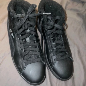Svarta sneakers från Puma med fodrad insida - Snygga svarta sneakers från Puma med snörning och rund tå. Skorna har en stilren design med Pumas logga på sidan. Perfekta för en casual look. Använda Max 2 gånger men passade inte i storlek. Det är storlek 38 