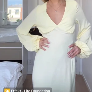 Ljusgul långklänning med öppen rygg - Slutsåld elegant ljusgul långklänning med v-ringning och långa ärmar. Klänningen har en stilren design med öppen rygg och är tillverkad i ett lätt och luftigt material.💛