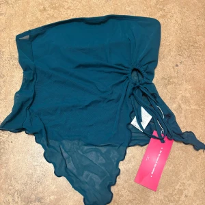 Blå omlottkjol med volang - Snygg blå omlottkjol med volangdetaljer och knytning i midjan. Perfekt för en stilfull look. Båda för 120kr