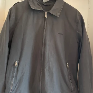 Svart jacka från Peak Performance - Säljer en svart jacka från Peak Performance. Jackan har en broderad logga på bröstet och krage. 2 fickor på sidorna och en innerficka. Använd men fortfarande i bra skick