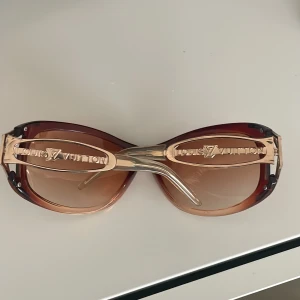 Solglasögon❤️ - Snygga solglasögon med bruna glas och guldfärgade detaljer. Bågarna har en elegant design med märkets logotyp på sidorna. Perfekta för en stilren look. Fina❤️