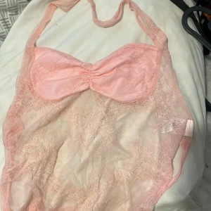 Rosa spetsklänning från Shein - Säljer en söt rosa spetsklänning från Shein. Klänningen har en vacker spetsdesign och är axelbandslös med en knytning i ryggen. Perfekt för sommarens fester! 💖