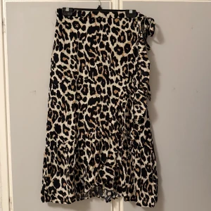 Kjol  - Lång och snygg leopardmönstrad omlottkjol med knytband i midjan från pernilla wahlgrens kollektion. 