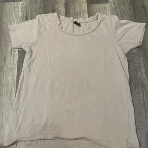 Ljusrosa t-shirt från Gina Tricot - En basic ljusrosa t-shirt från Gina Tricot i mjuk bomull. Modellen har rund halsringning och korta ärmar, perfekt för en enkel och clean look. Passar dig som gillar minimalistisk stil.