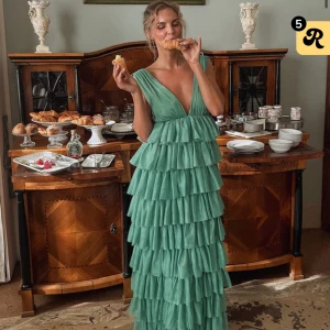 Grön volangklänning med djup v-ringning - Säljer denna superfina volangklänning från Lovisa Wallin x NA-KD. Helt slutsåld i alla storlekar och endast testad! Nypris 1899kr