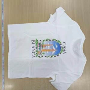  Casablanca - Vit t-shirt från Casablanca med färgglatt tryck framtill som föreställer en portal med växter och blå himmel. T-shirten har rund halsringning och korta ärmar. Perfekt för en stilren och trendig look.