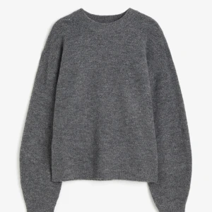 Grå stickad tröja - Mysig grå stickad tröja med rund halsringning och långa ärmar. Perfekt för kyliga dagar och enkel att matcha med olika outfits. Klassisk och stilren design som passar till det mesta.