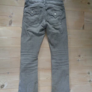 Lågmidjade bootcut jeans - Lågmidjade utsvängda jeans från Gina tricot med detaljerade fickor, midjemått: 37 cm, innerbenslängd: 82 cm