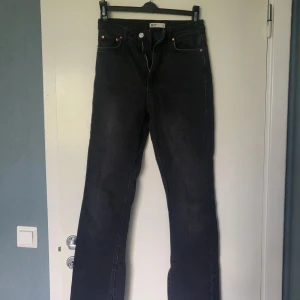 Mörkgrå jeans  från gina tricot - Säljer ett par svarta jeans från gina tricot i storlek 34. Jeansen har raka ben och råa, fransiga benslut, de är även högmidjade. Köpta från petite kategorin i gina , passar perfekt för oss kortisar som är 160 och under.