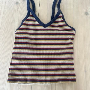 Randig ribbad linne från Monki - Säljer en färgglad ribbad linne från Monki i storlek XXS. Toppen har smala axelband och v-ringning. 