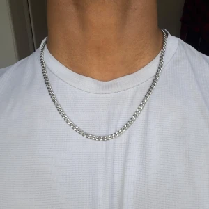 Kedjehalsband i silverfärg 55cm - Säljer ett stilrent halsband i silverfärgad metall med klassisk kedjedesign. Passar perfekt för dig som vill ha en enkel men snygg accessoar till din outfit.