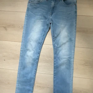 Ljusblå jeansbyxor från Levi's - Säljer ett par ljusblå jeansbyxor från Levi's med klassisk femficksdesign och raka ben. Jeansen har en diskret tvättad look och normal passform. Nypris 1099 säljer nu för 200 storlek S.