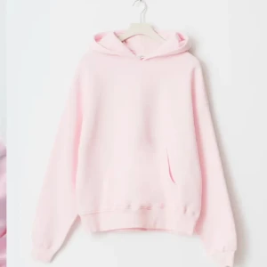 Ljusrosa hoodie - Säljer en ljusrosa hoodie med huva och magficka. Tröjan har långa ärmar och ribbade muddar vid ärmslut och nederkant. Perfekt för en avslappnad stil.