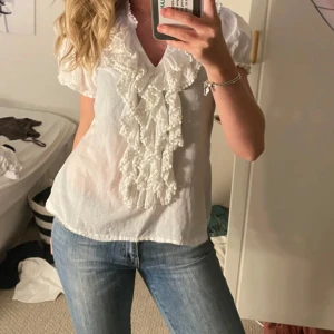 Vit volangblus Saint Tropez - Jättefin eftertraktad volangblus som passar perfekt till sommaren! 😍Har litet hål som kan sys igen och få fläckar som borde gå bort i tvätten. Nypris 499 kr men säljs billigare därav defekterna 