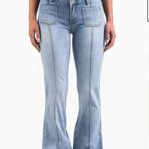 Madlady Jeans - Snygga ljusblå jeans med bootcut passform och markerade sömmar framtill. Jeansen har två stora framfickor och klassisk knappgylf. Perfekta för en trendig och avslappnad look. Har en typ lite öppen söm där framme stör inte super mycket och går säkert och fixa, säljer för jag tröttnat på dom💕💕